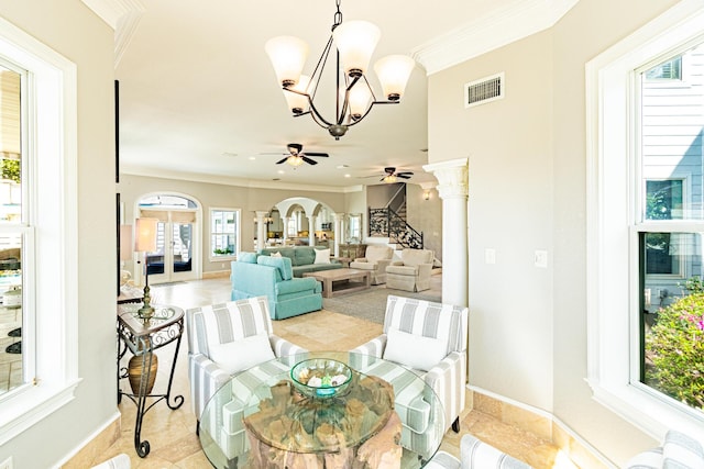 dining space featuring ceiling fan with notable chandelier, ornamental molding, and decorative columns