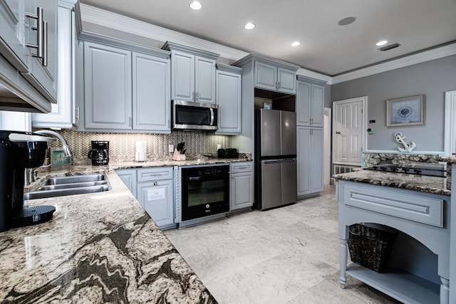 kitchen with appliances with stainless steel finishes, decorative backsplash, dark stone countertops, crown molding, and sink