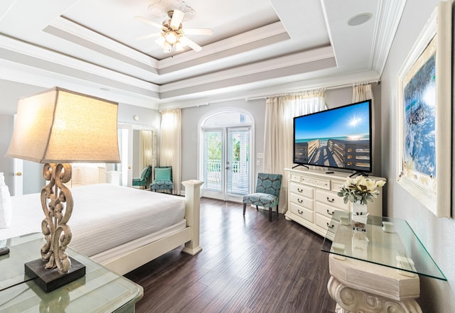 bedroom featuring ceiling fan, access to outside, a tray ceiling, dark wood-type flooring, and ornamental molding