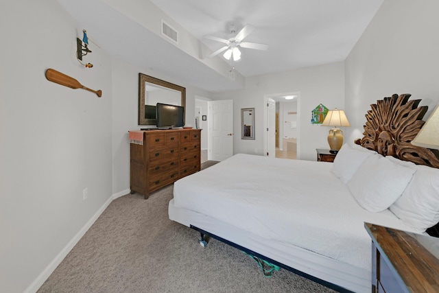 bedroom featuring light carpet, ceiling fan, and ensuite bath