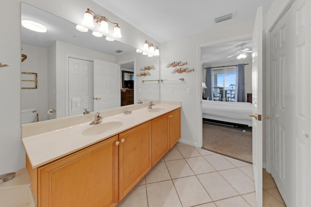 bathroom with ceiling fan, dual sinks, oversized vanity, toilet, and tile floors