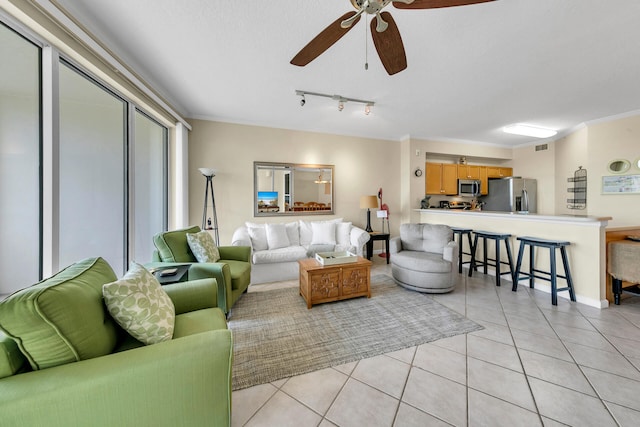 living room with rail lighting, ceiling fan, light tile flooring, and ornamental molding