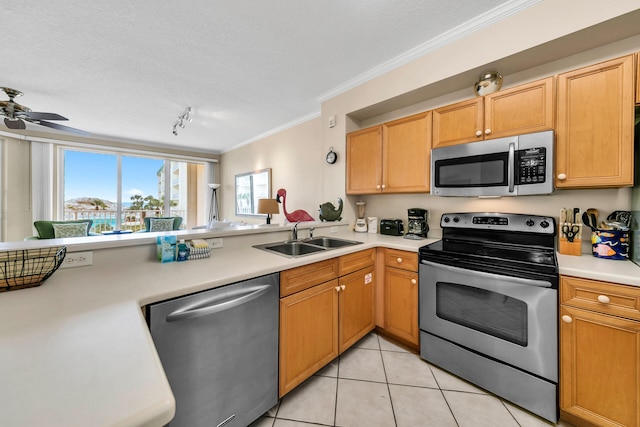 kitchen with ornamental molding, appliances with stainless steel finishes, light tile floors, sink, and ceiling fan