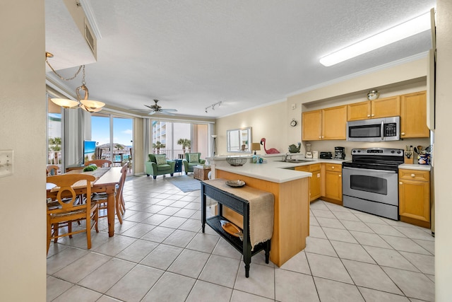 kitchen with pendant lighting, light tile flooring, ornamental molding, kitchen peninsula, and appliances with stainless steel finishes