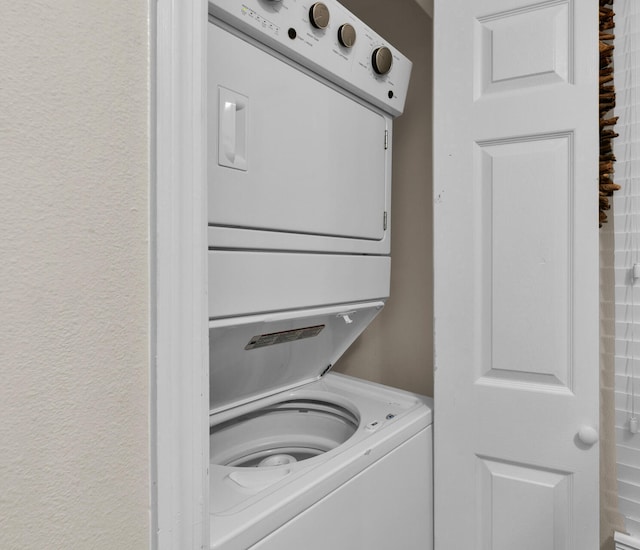 clothes washing area featuring stacked washer / dryer