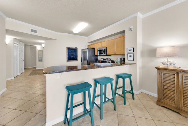 kitchen with crown molding, stainless steel appliances, and a kitchen bar