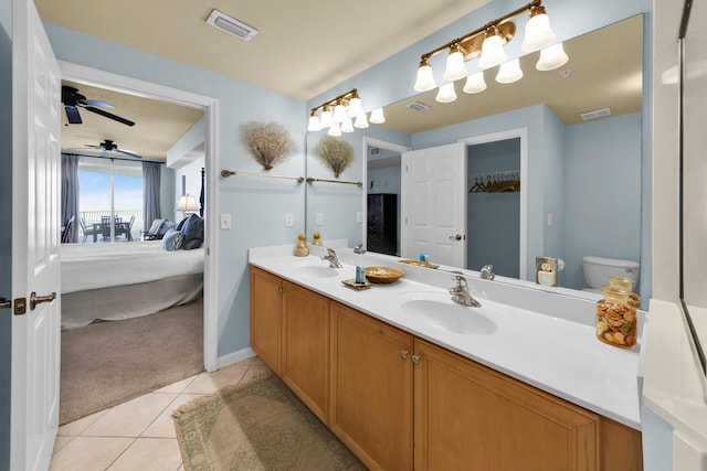 bathroom with oversized vanity, tile flooring, dual sinks, toilet, and ceiling fan