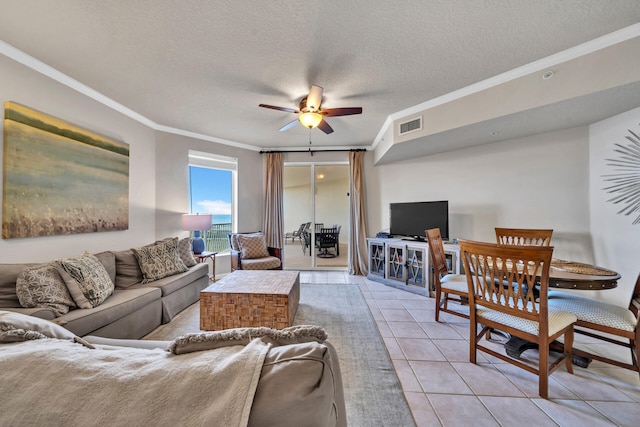 tiled living room featuring a textured ceiling, ceiling fan, and ornamental molding