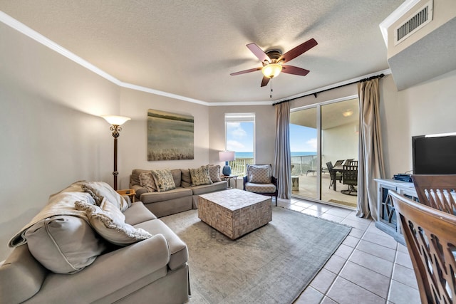 tiled living room featuring a textured ceiling, ceiling fan, and crown molding