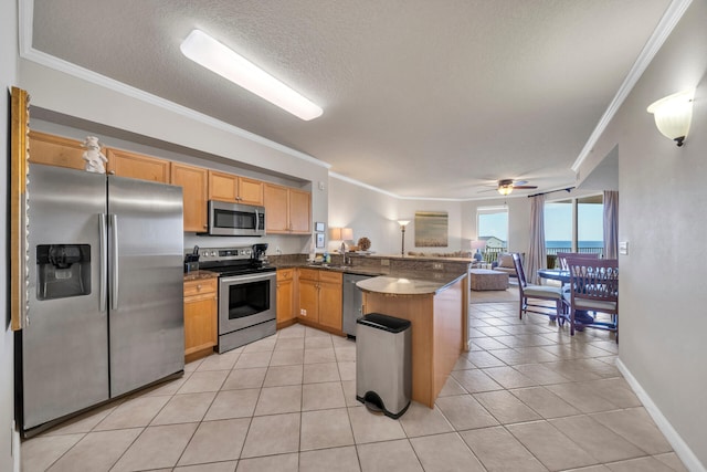 kitchen with light tile flooring, ornamental molding, kitchen peninsula, appliances with stainless steel finishes, and ceiling fan