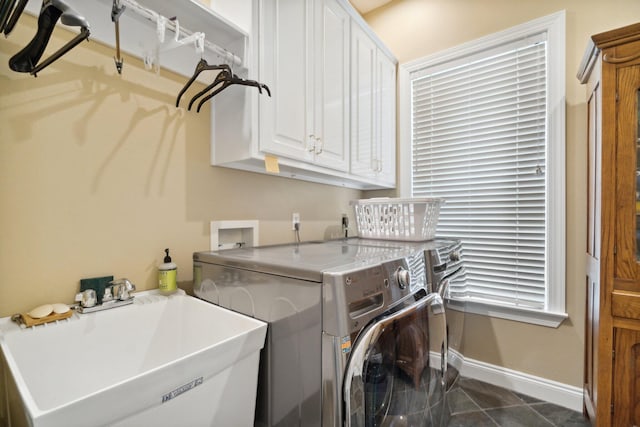 clothes washing area featuring cabinets, dark tile flooring, independent washer and dryer, and sink