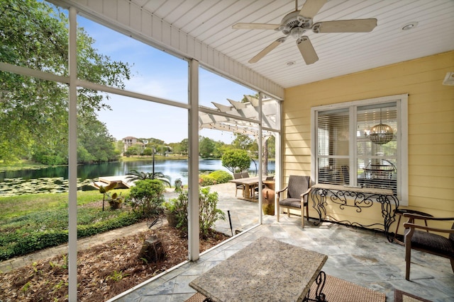 sunroom / solarium with a water view and ceiling fan