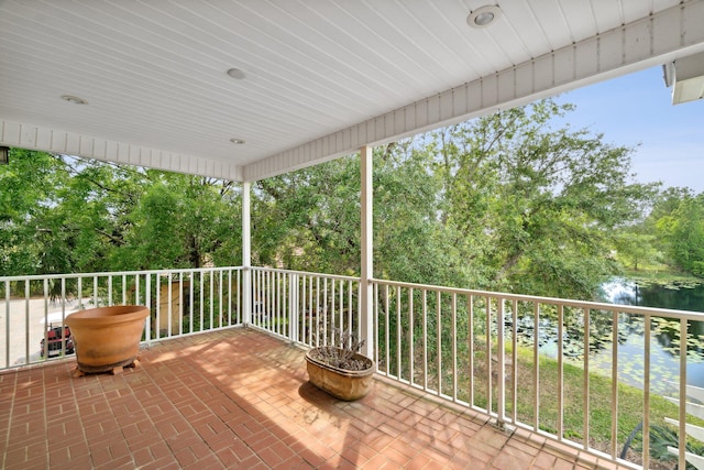 view of patio featuring a water view and a balcony