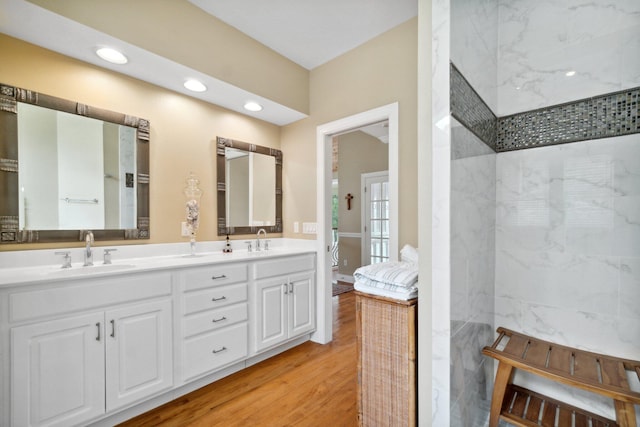 bathroom featuring oversized vanity, hardwood / wood-style floors, and dual sinks