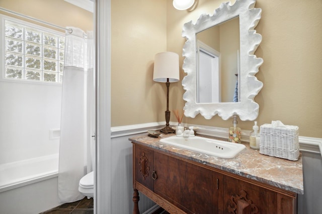 bathroom with vanity with extensive cabinet space, toilet, and tile flooring