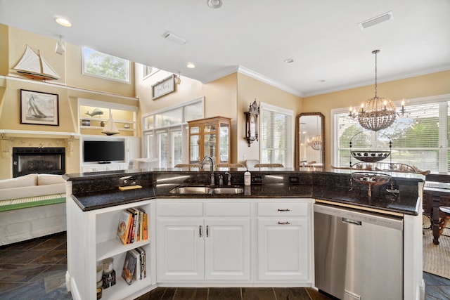 kitchen with sink, dishwasher, dark stone counters, and an inviting chandelier