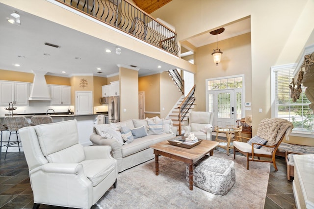 tiled living room with a wealth of natural light, ornamental molding, and a towering ceiling