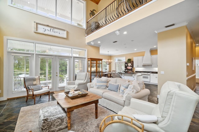 living room featuring a notable chandelier, dark tile flooring, french doors, and a towering ceiling