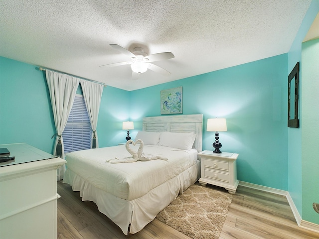 bedroom featuring a textured ceiling, light hardwood / wood-style floors, and ceiling fan