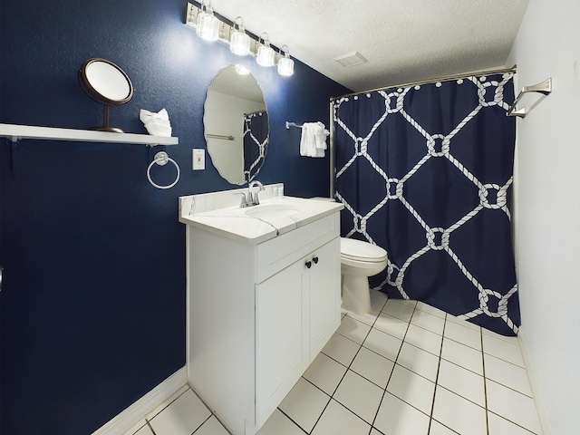 bathroom featuring toilet, vanity, a textured ceiling, and tile patterned floors