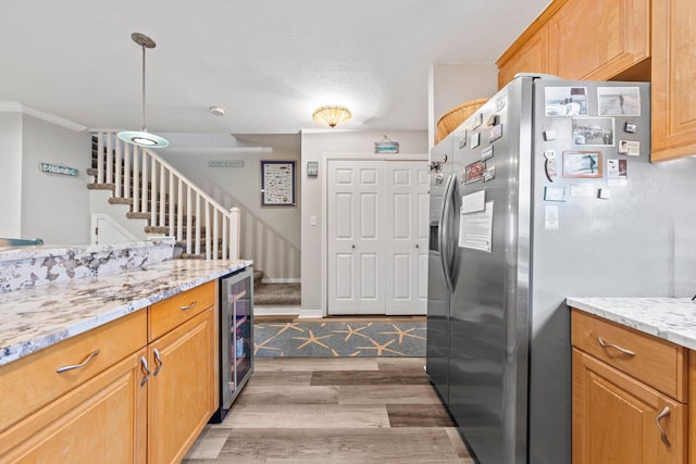 kitchen featuring decorative light fixtures, beverage cooler, stainless steel refrigerator with ice dispenser, hardwood / wood-style flooring, and light stone counters