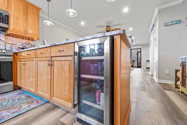 kitchen with light stone counters, ceiling fan, range, light wood-type flooring, and ornamental molding