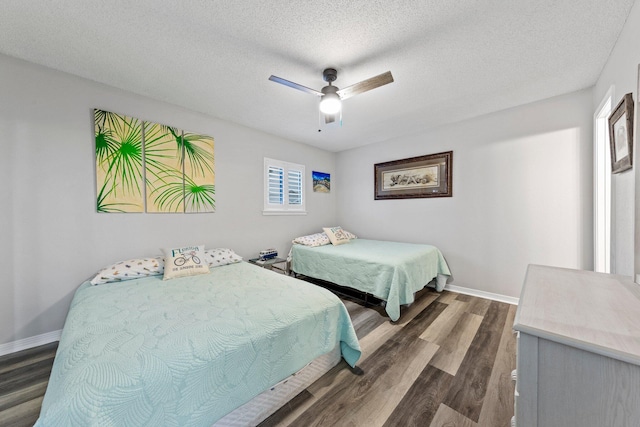 bedroom with dark hardwood / wood-style flooring, ceiling fan, and a textured ceiling