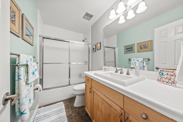 full bathroom with shower / bath combination with glass door, vanity, tile floors, and toilet