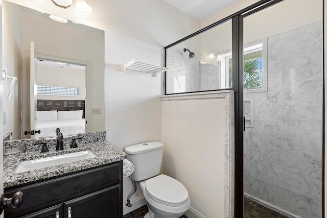 bathroom featuring large vanity, a shower with shower door, and toilet