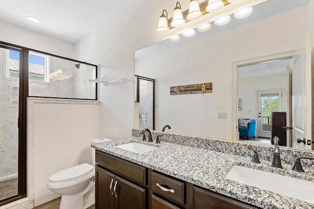 bathroom with double vanity, an enclosed shower, and toilet