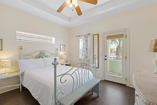 bedroom featuring a raised ceiling, ceiling fan, access to exterior, and dark hardwood / wood-style floors