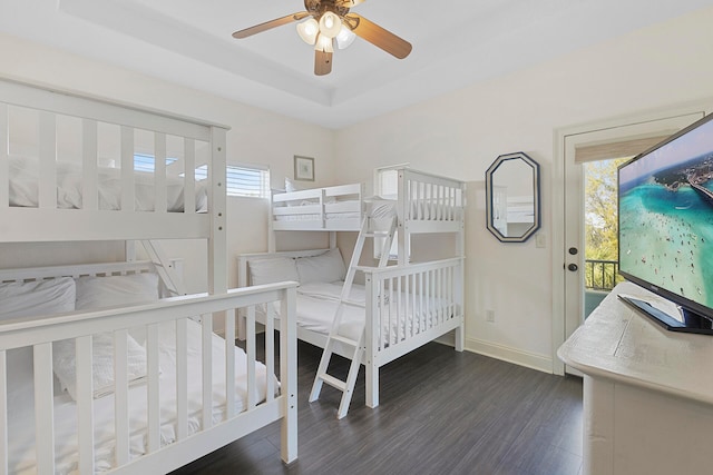 bedroom featuring dark wood-type flooring, ceiling fan, and a raised ceiling