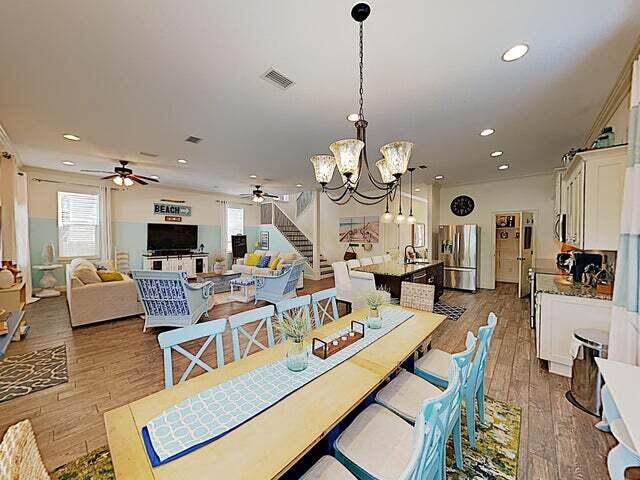 dining room with sink, ceiling fan with notable chandelier, and light wood-type flooring