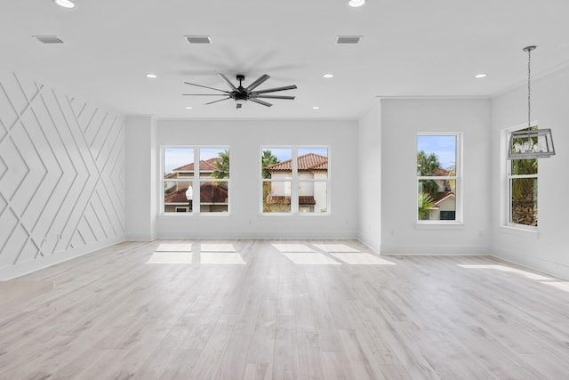 unfurnished living room featuring a wealth of natural light, ceiling fan, light hardwood / wood-style floors, and ornamental molding