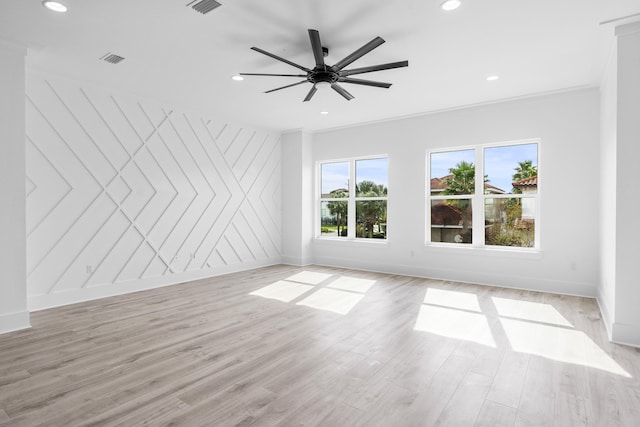 spare room featuring ceiling fan, crown molding, and light wood-type flooring