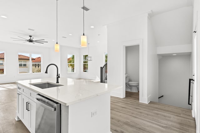 kitchen with light hardwood / wood-style flooring, dishwasher, an island with sink, white cabinetry, and sink