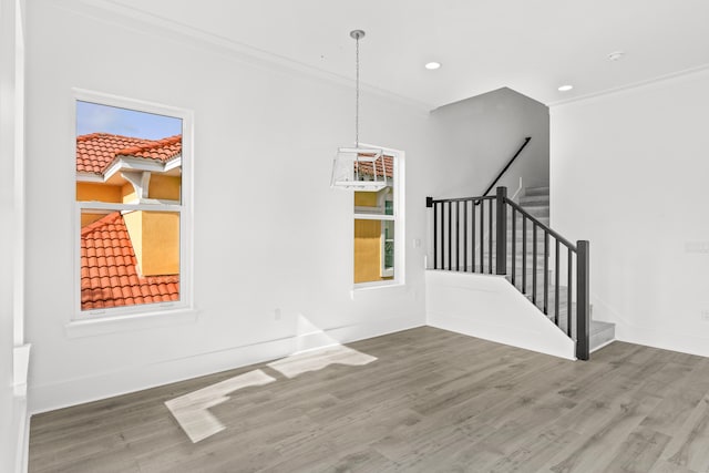 empty room with ornamental molding, a notable chandelier, and dark wood-type flooring