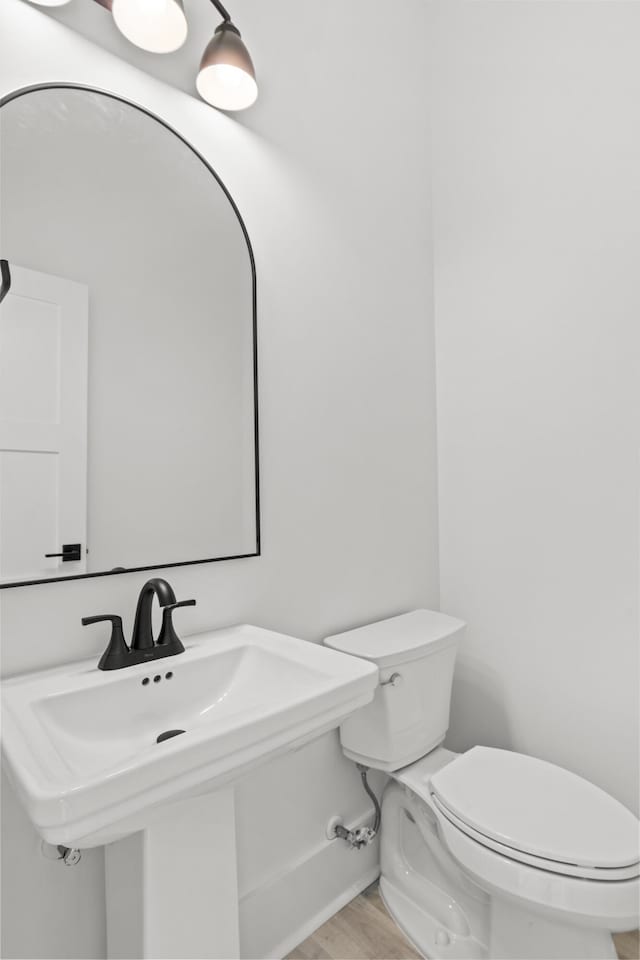 bathroom with wood-type flooring, sink, and toilet