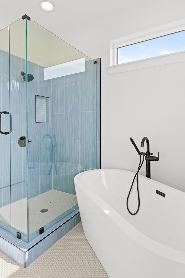 bathroom with tile flooring and independent shower and bath