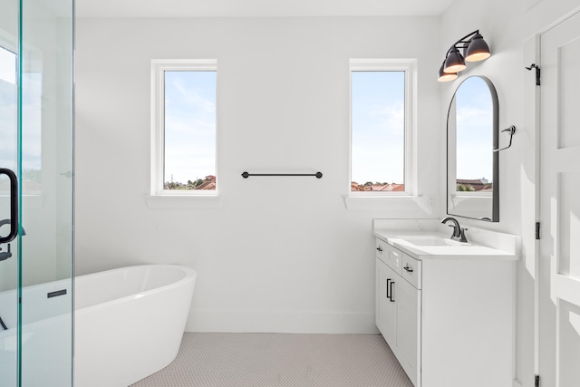 bathroom with tile flooring, vanity with extensive cabinet space, and a bathtub