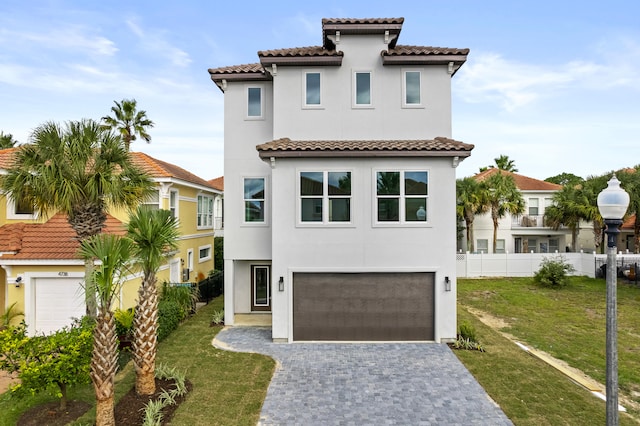 mediterranean / spanish-style house featuring a garage and a front lawn