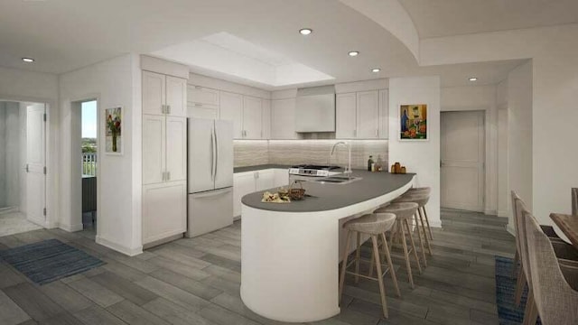 kitchen featuring backsplash, white refrigerator, white cabinetry, sink, and light wood-type flooring