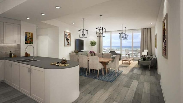 kitchen with floor to ceiling windows, white cabinetry, sink, and dark wood-type flooring