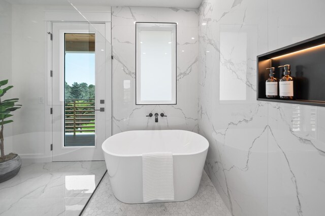 bathroom featuring a tub to relax in and tile walls