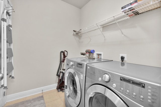 laundry area with electric dryer hookup, washer hookup, washing machine and dryer, and light tile flooring