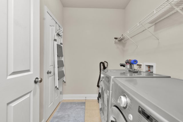 laundry room featuring light tile flooring, hookup for a washing machine, and washer and dryer