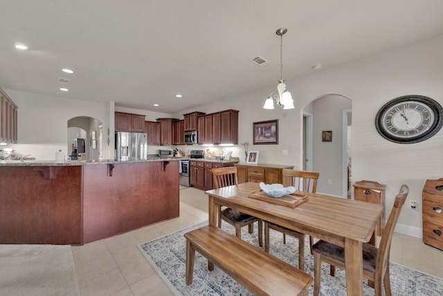 dining space featuring a notable chandelier and light tile floors