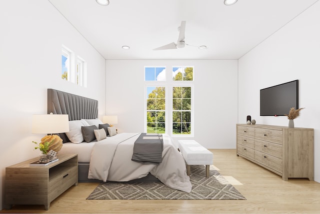 bedroom featuring light hardwood / wood-style floors, ceiling fan, and multiple windows