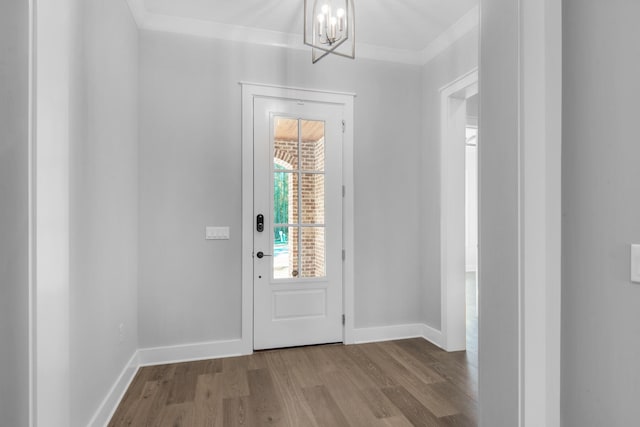 doorway to outside featuring light hardwood / wood-style flooring, a notable chandelier, and crown molding