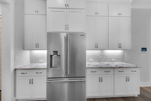 kitchen with white cabinets, tasteful backsplash, stainless steel fridge with ice dispenser, light stone countertops, and dark hardwood / wood-style flooring